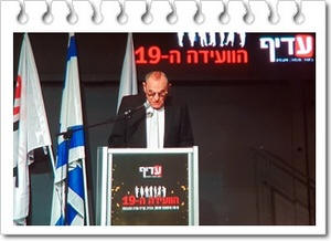 לוי יצחק נואם בועידה ה19 של עדיף תקשורת, צילום קטיה שורצמן